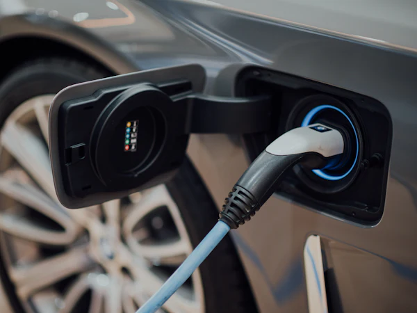 A charging cable plugged into the socket of an electric car