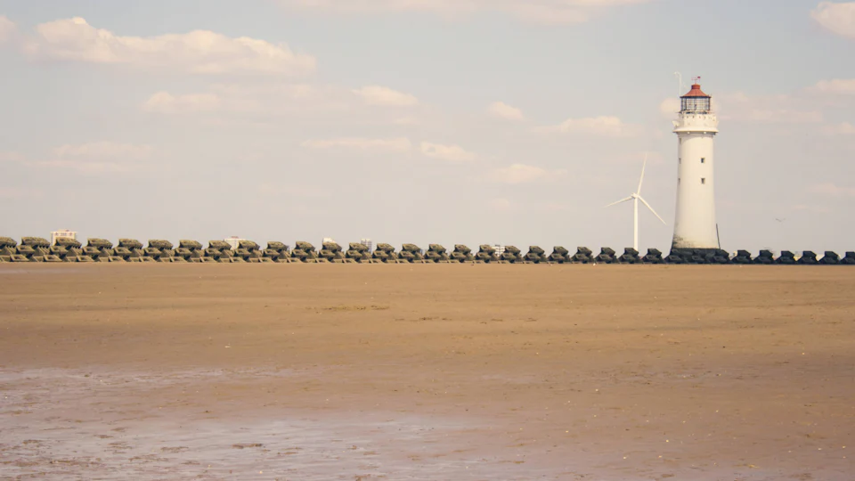 Perch Rock lighthouse and the sea wall seen across the sand at low tide