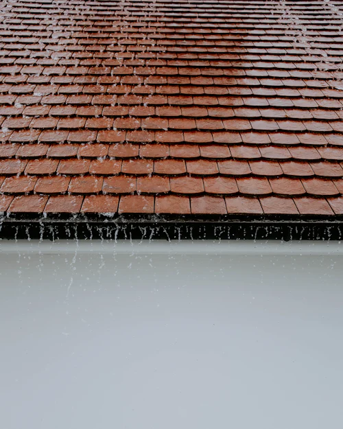 Rain running off the eaves of a clay tile roof
