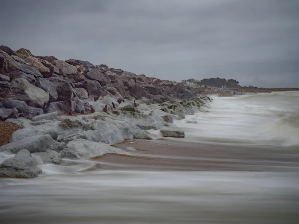 Rock armour along a sea wall with the tide washing through it