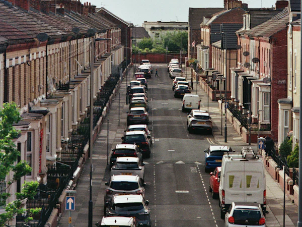 A long street of red brick terraces seen from above, slate roofs running to the end