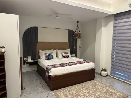 A bedroom against a wall of exposed stone.