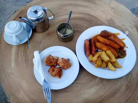 A mesa comprida posta na varanda.