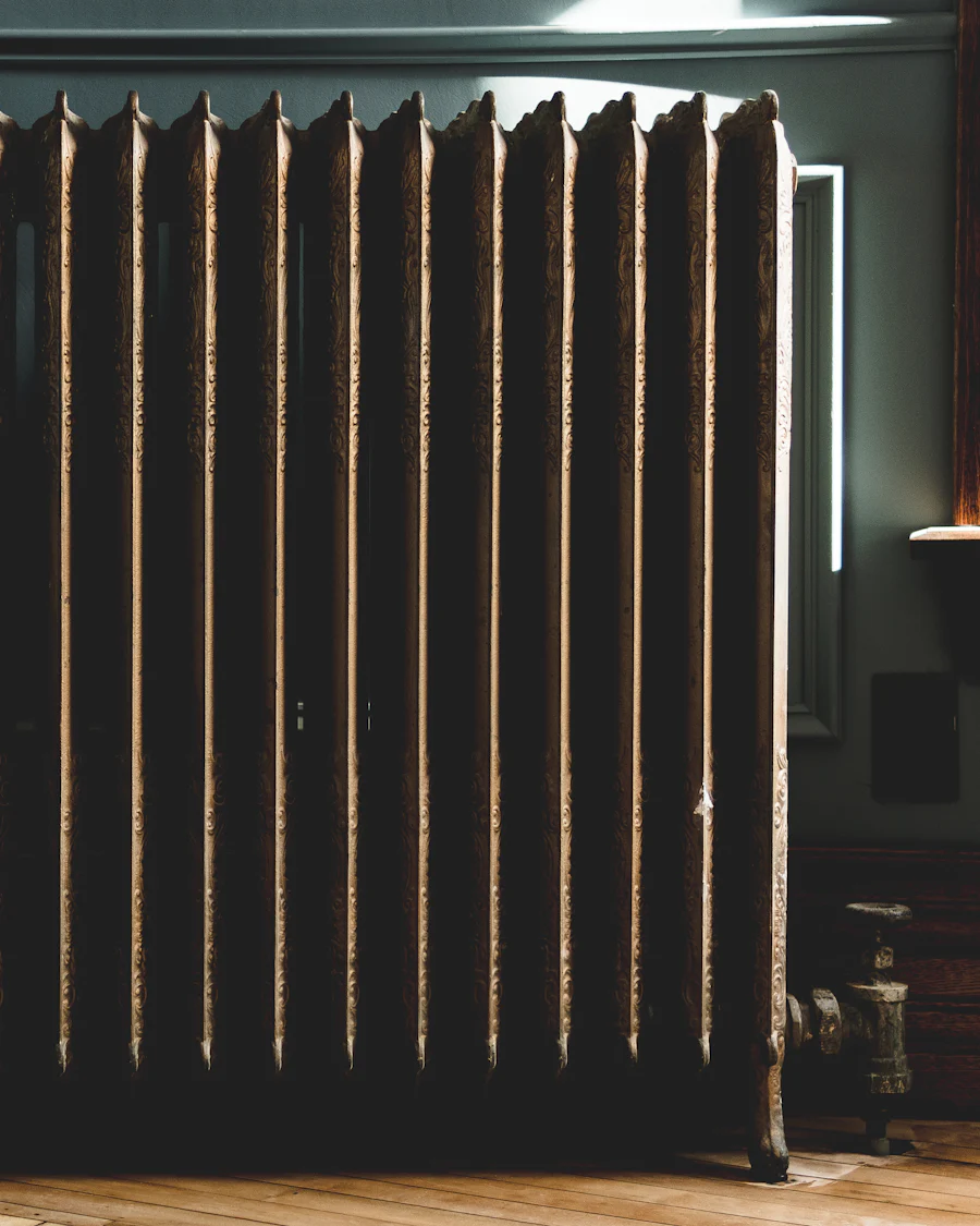 A tall Victorian cast iron column radiator against a dark wall