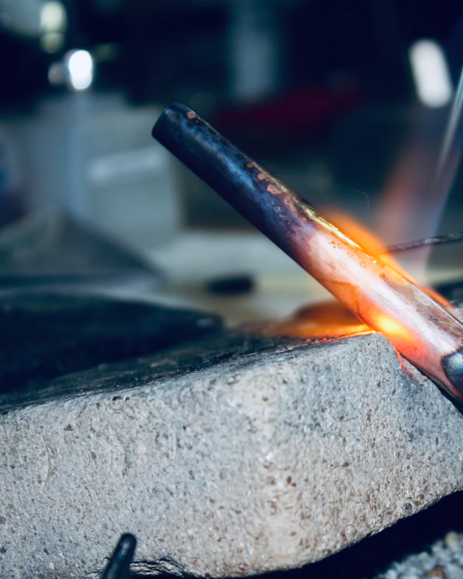 A copper pipe being heated with a torch flame as a joint is soldered