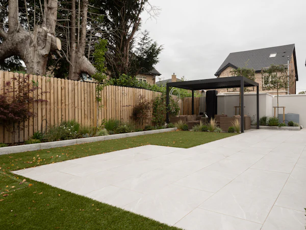 A new pale porcelain patio and lawn behind a timber fence