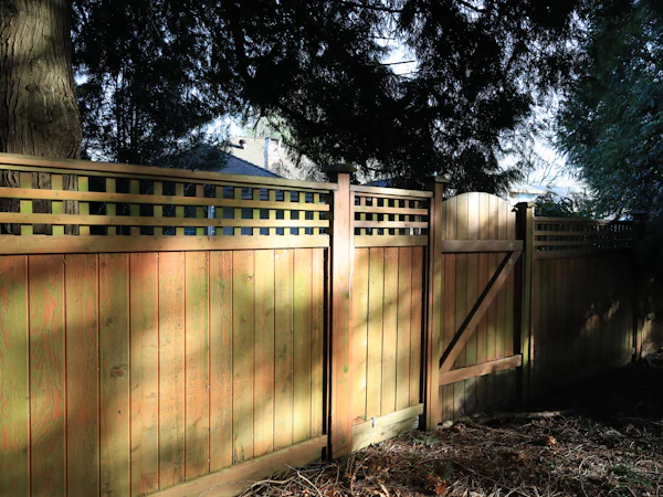 A closeboard timber fence with a trellis top and a matching gate