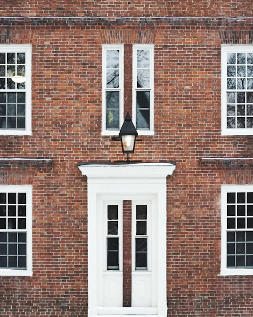 A symmetrical red-brick Georgian front with white six-over-six sashes and a white doorcase