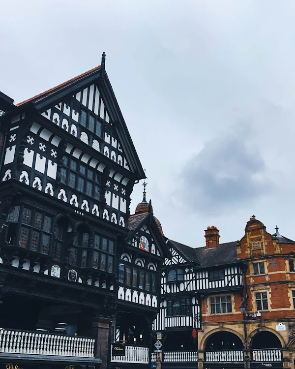 Black-and-white timber revival frontages above a covered gallery, with a red-brick building beyond