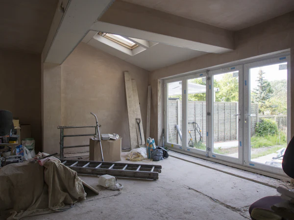 A new extension with plastered walls and a roof light, glazed doors to the garden