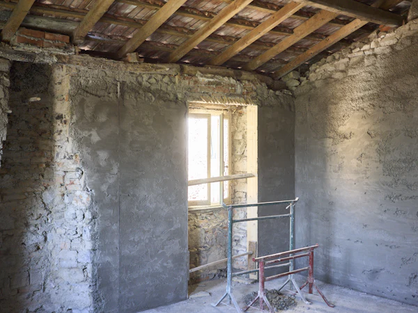An old solid-walled room stripped back to stone and brick, a trestle by the window