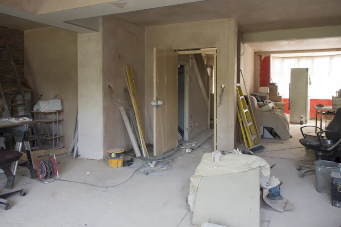 A room mid-job with the floor sheeted, tools and buckets kept to one side