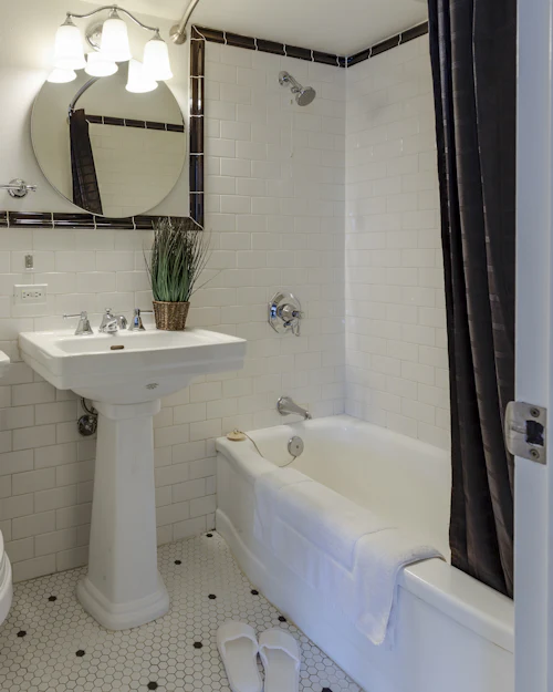 A classic white metro bathroom with a pedestal basin, a bath and a hexagonal mosaic floor