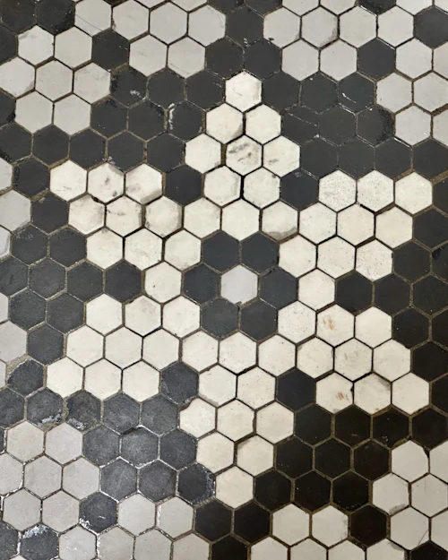 A floor of small black and white hexagonal mosaic tiles in a scattered pattern