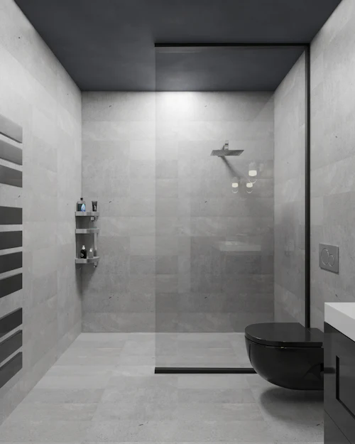 A walk-in shower in large grey porcelain tiles with a linear drain and a black ceiling
