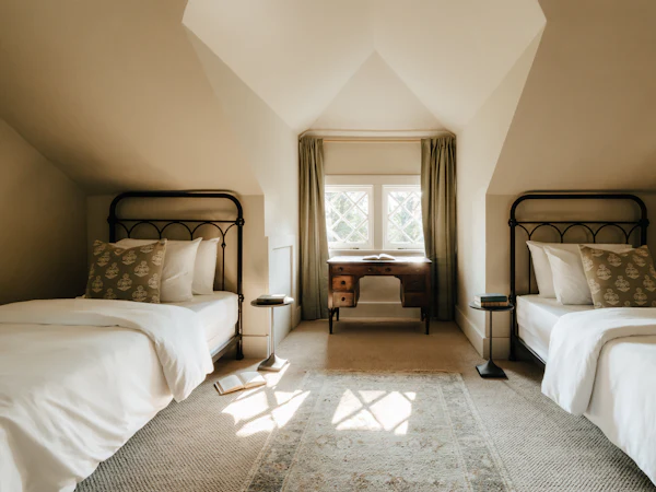A loft room with two single beds under the slopes and a window between them