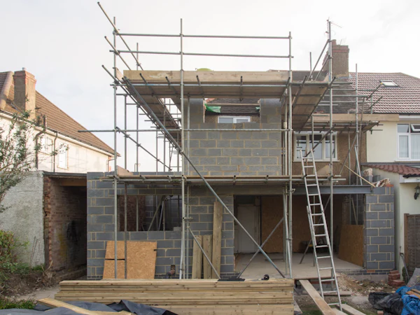 Scaffold up the back of a semi-detached house, the new upper floor in blockwork